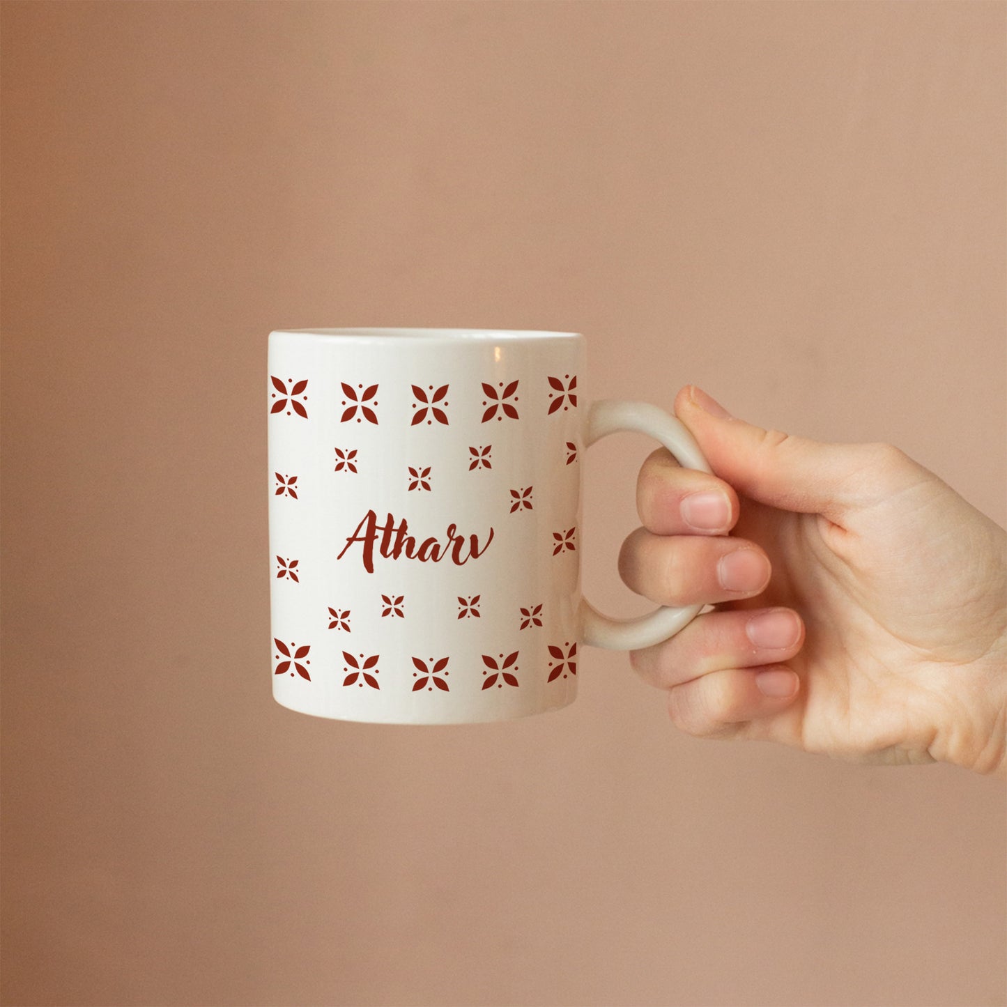 Hand holding personalized ceramic mug with desi design