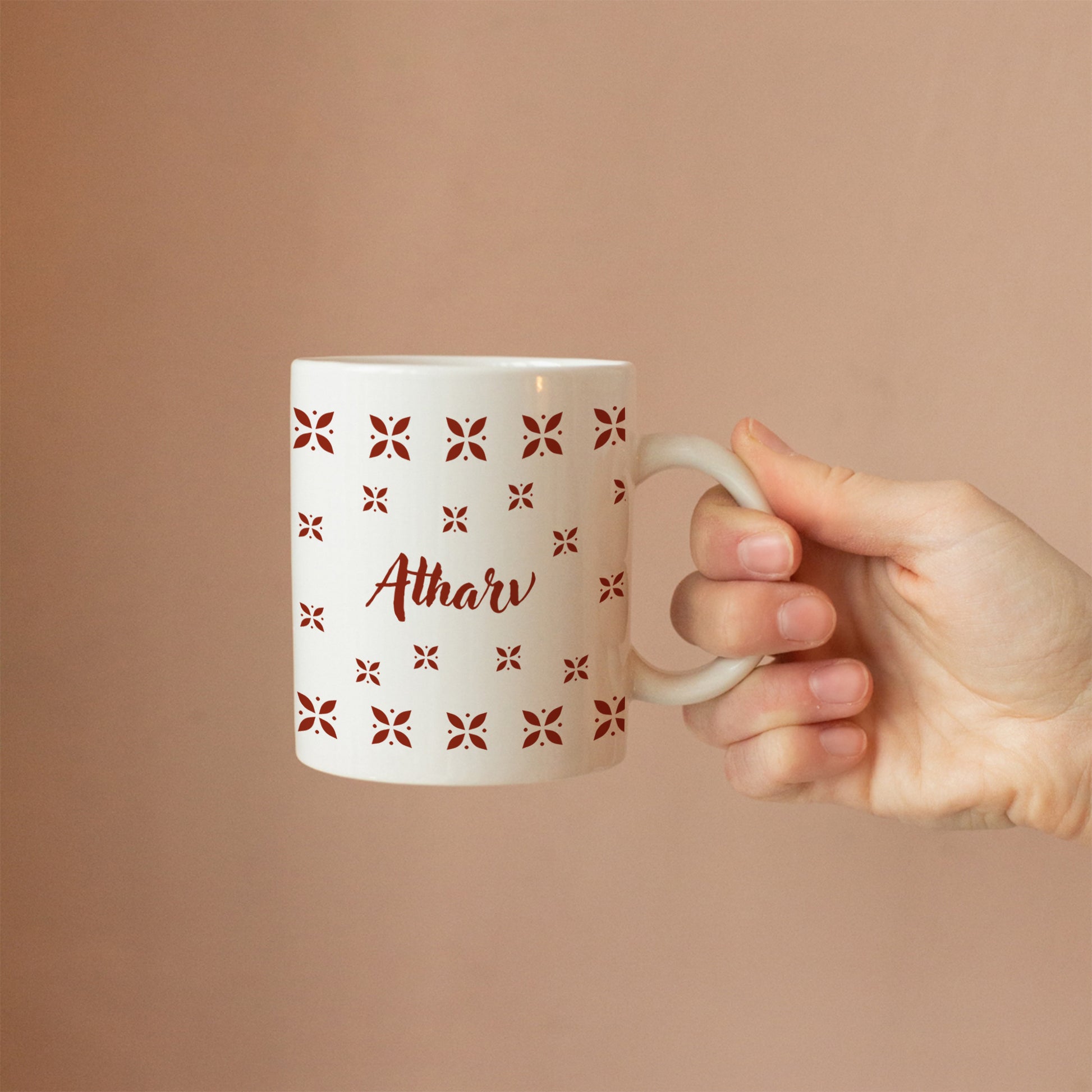 Hand holding personalized ceramic mug with desi design