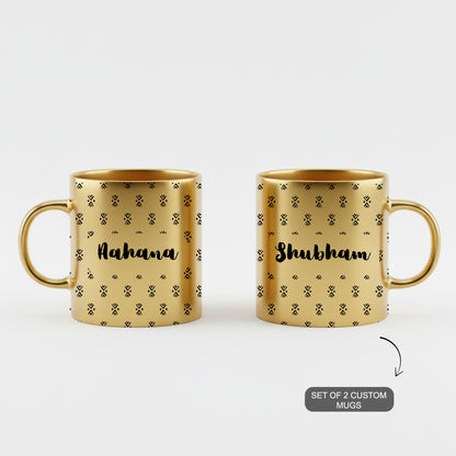 Pair of golden custom mugs with ethnic designs and personalized names.