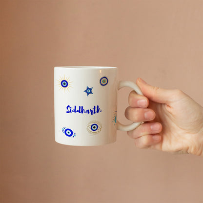 Hand holding custom ceramic evil eye mug with personalized name